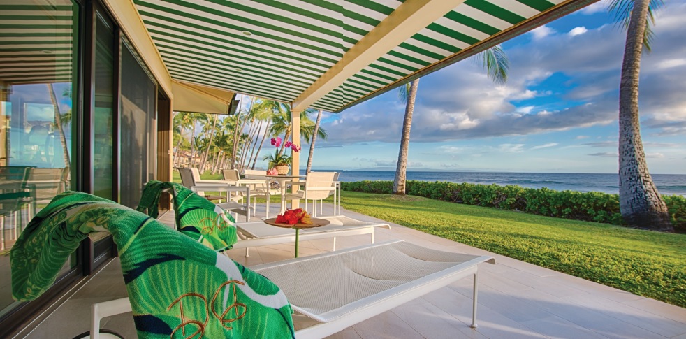 Knoll 1966 outdoor furnishings sit on the lanai, which has a green-and-white-striped covering to complete the cabana feel. PHOTO BY JOE D’ALESSANDRO