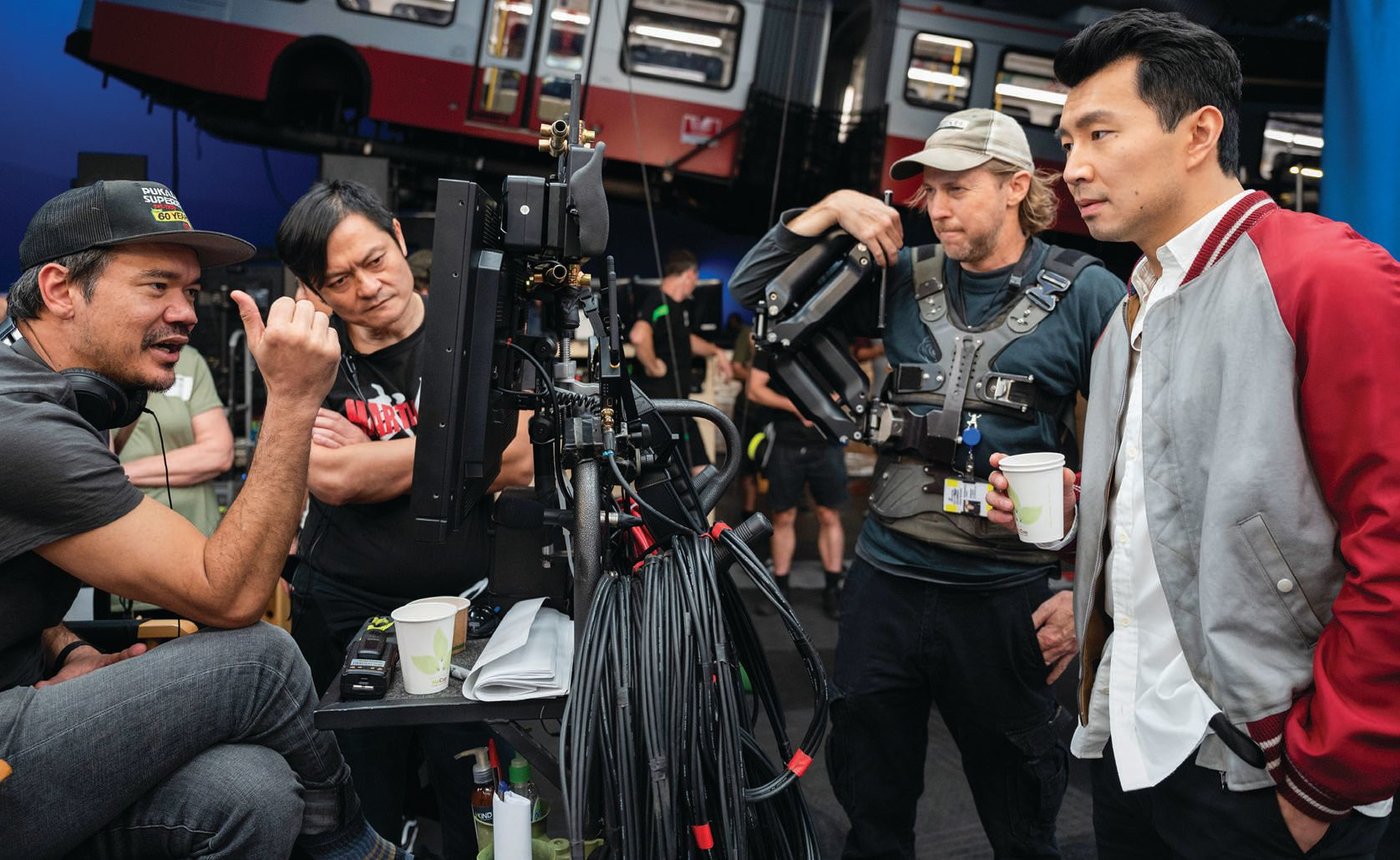 Director Destin Daniel Cretton, fight instructor Alan Tang, a crew camera operator and Simu Liu on the set of the film PHOTO BY JASIN BOLAND ©MARVEL STUDIOS 2021